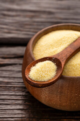 Wheat semolina in a wooden spoon and bowl - Triticum