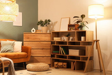 Interior of living room with bookshelf and glowing lamps in evening