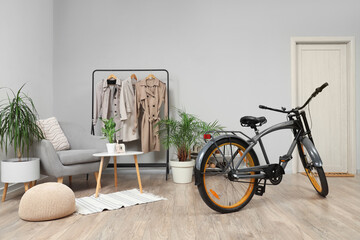 Interior of hallway with modern bicycle, armchair and coat rack