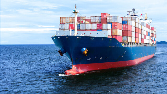 Aerial of cargo ship carrying container  for export cargo from cargo yard port to other ocean concept smart freight shipping ship front view