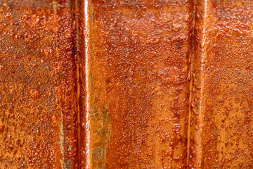 Close-up of a weathered, rusty metal surface with vertical lines and texture. 
a close up of a...