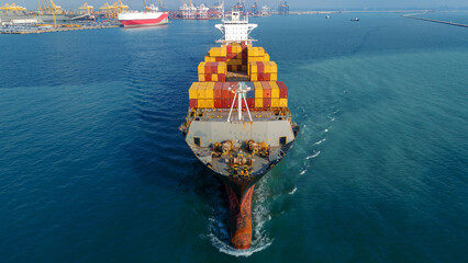 Aerial of cargo ship carrying container export cargo from cargo yard port to other ocean concept...