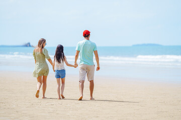 Beach Family Vacation in Summer, Happy Parents Holding Hands with Daughter Walking Together on Sandy Shoreline in Relaxing Outdoor Holiday Moment