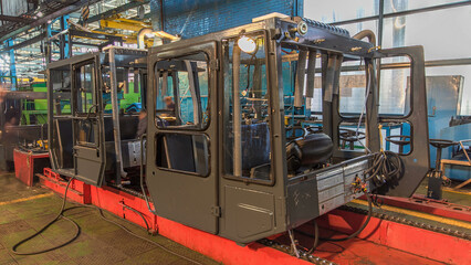 Conveyor assembly stage the body of tractor at big industrial factory timelapse