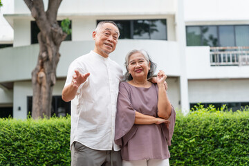 Happy Senior Asian Couple Standing Together Outdoors, Portrait of a Smiling Elderly Asian Pair in Front of Home