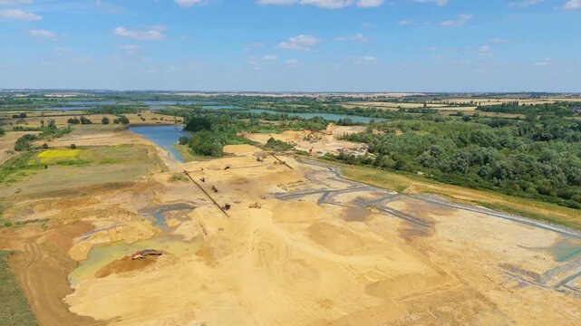 Drone aerial view of active quarry site in Little Paxton England with excavators and diggers working in mineral pit