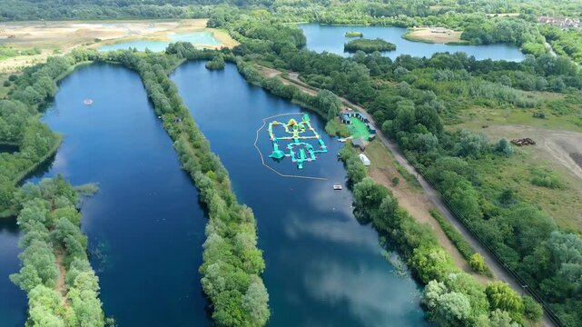 Scenic drone footage of family-friendly aqua park on vibrant blue lake in the English countryside, Little Paxton