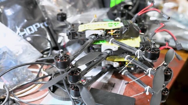A detailed close-up of an FPV 'kamikaze' drone being assembled in a Ukrainian workshop. This low-cost, expendable tech provides a key tactical advantage on the modern battlefield.