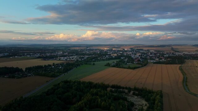 The city of Svitavy on a summer evening with large clouds over the city. A developing family quarter of new buildings. Drone view