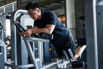 Dedicated individual performs strength training exercises in a modern gym during afternoon fitness...