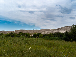 A grassy field with a hill in the background