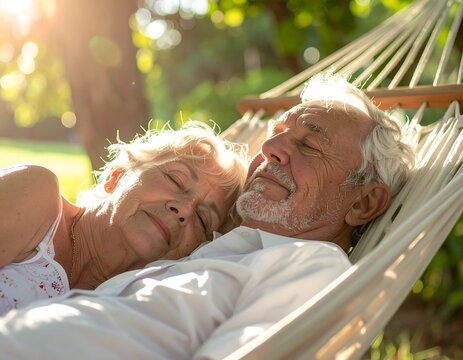 Serene senior couple enjoying a peaceful nap together in a hammock on a sunny afternoon in the garden.