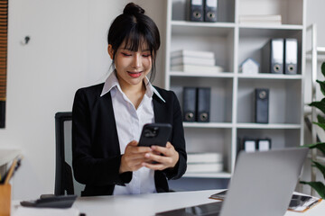 Young Asian Japanese business woman executive holding cellphone device using mobile cell phone...