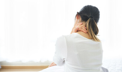 Young woman holding her neck with her hand due to severe neck pain from tendon spasm, muscle aches, Medical and healthcare concept