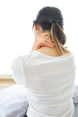 Young woman holding her neck with her hand due to severe neck pain from tendon spasm, muscle aches, Medical and healthcare concept