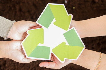 Hands Gently Holding Recycling Symbol, Promoting Environmental Care