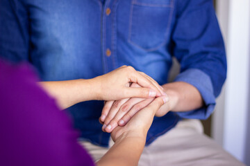 Nurse comforting patient by holding hands, showing empathy and compassion