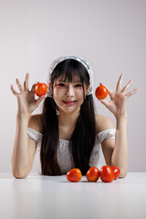 Beauty image of a young Health Asian girl show tomato with smiley face, health food concept, asian woman beauty a background of light and shadow 