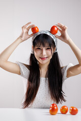 Beauty image of a young Health Asian girl show tomato with smiley face, health food concept, asian woman beauty a background of light and shadow 