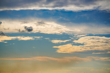 Beautiful evening sky with colorful orange and blue clouds reflecting on the water at dusk. Serene and peaceful nature background.