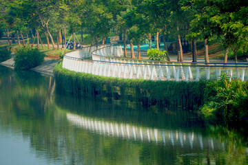 Greenbelt, PIK 2 - Jakarta, June 26, 2025 : A serene urban park in Jakarta, Banten, Indonesia, featuring a tranquil lake surrounded by lush green trees and walking paths, ideal for relaxation.