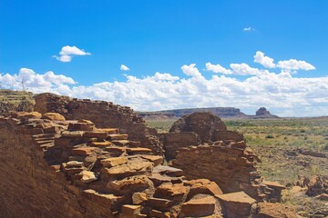 Part of Chaco Canyon Pueblo with a cliff and sky with clouds in the background, New Mexico.