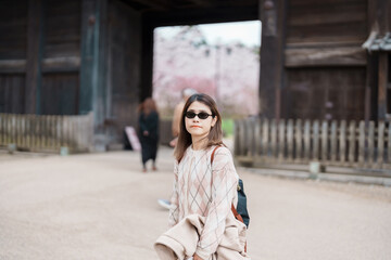 Woman tourist sightseeing Hirosaki Castle with Sakura Cherry Blossom in Spring, happy traveler...