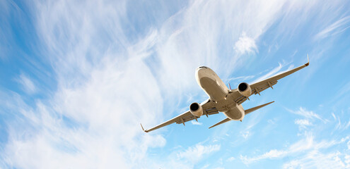 White passenger airplane flying in the sky amazing clouds in the background - Travel by air...