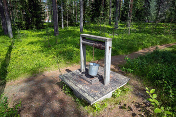 water well with broken metal bucket in the woods