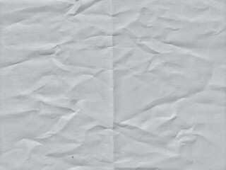 Crumpled white paper texture with fold lines. Crumpled blank white paper folded in two fraction...