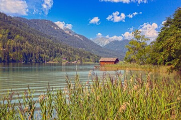 Boat dock on Weissensee with alpine forest background
