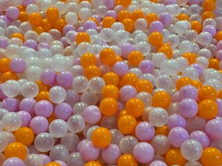 photo of ball pit, playground, bubble, colorful background, orange, purple, white, pearl, plastel