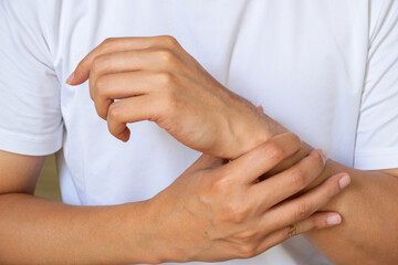 Asian man with wrist pain after housework, showing strain and recovery—perfect for healthcare,...