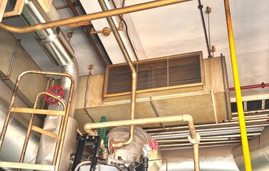 Old industrial exhaust ventilation with rust and corrosion on factory wall. Weathered ductwork and...