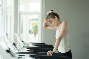 Woman, Running and exercising. Woman running on treadmill in gym. Young woman wearing sportswear...