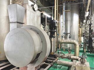 Industrial boiler room with stainless steel tanks, pipelines, valves, and ventilation system. Clean...