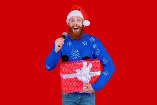 Happy 2024 New Year. Christmas shopping sale. Xmas sale announcement. Santa man with microphone and gift isolated on red. Christmas present. New Year holiday shopping sale. Sing Christmas carols