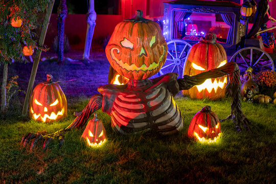 Big figure of angry pumpkin ay night. Halloween outdoor decor. Scary Jack o lantern