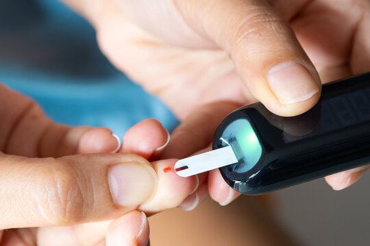 hand of people check diabetes and high blood glucose monitor with digital pressure gauge. Healthcare and Medical concept	