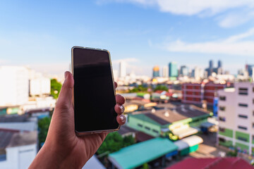 Smartphone in Hand with City Skyline