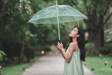 Lifestyle photography teenage girl with clear umbrella in a serene nature setting