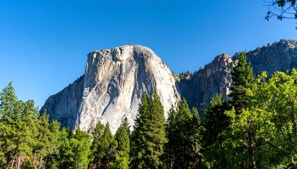 Obraz premium Majestic granite peak rising above a lush forest
