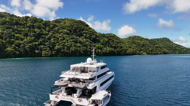 Epic cinematic aerial drone shot hovering and revealing the radiant blue waters and wild island landscapes in Palau. Revealing drone shot of yacht