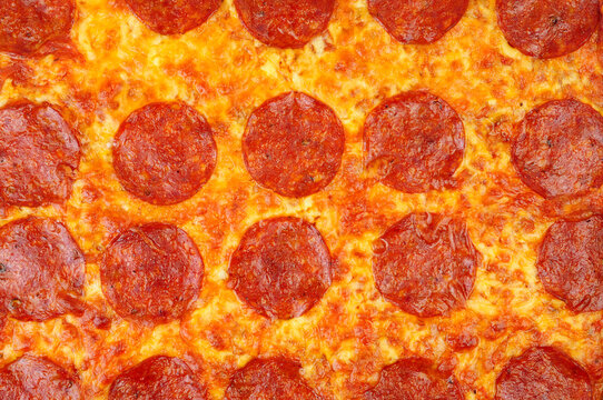 Baked spicy pepperoni and cheese pizza background texture detail