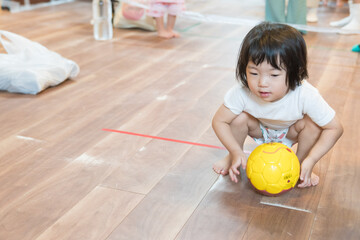 保育園でボーリングゲームで遊ぶ女の子の幼児