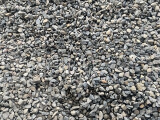 A close-up view of a gray gravel surface with various sizes of stones.