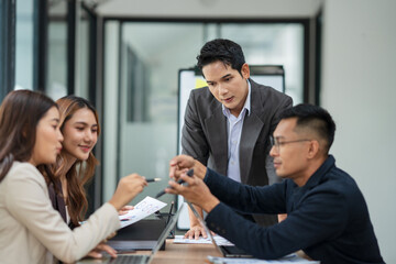 Group of business people are standing in a meeting presenting their work at the office.