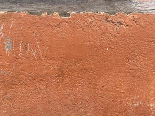 Close-up of textured orange wall with scratches and wear marks.