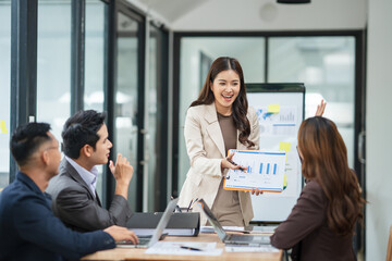 Group of business people are standing in a meeting presenting their work at the office.