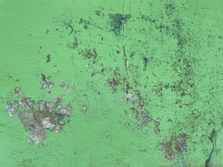 Textured green surface with peeling paint and visible imperfections.